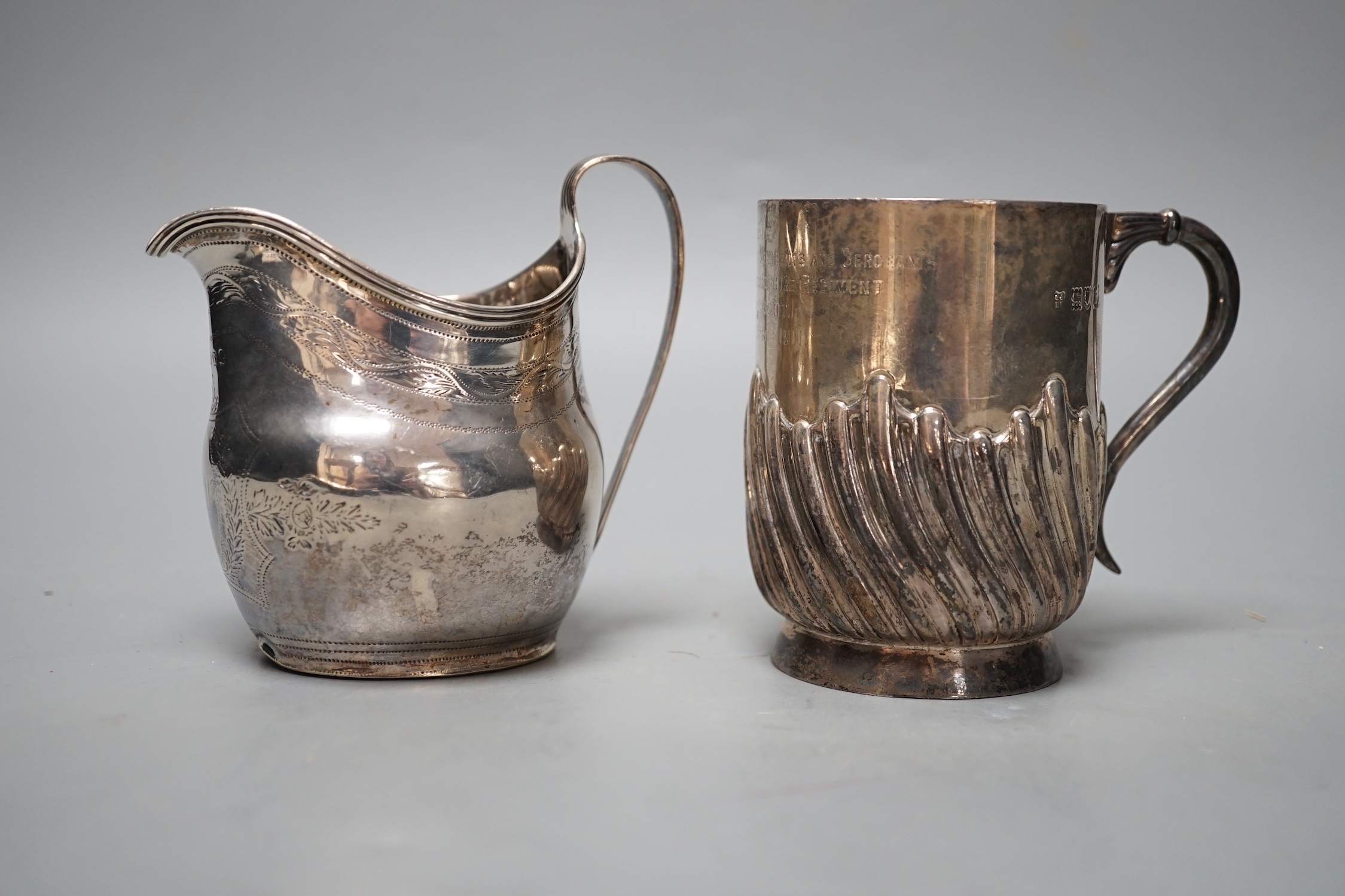 A George III silver cream jug, London, 1800, a later silver mug and a white metal and enamelled initiallled clip?, gross 8.5oz.